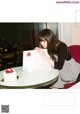 A woman sitting at a table with a cake in front of her.