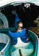 A woman riding a blue and white whale on a water slide.