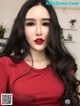 A woman with long black hair wearing a red shirt.
