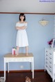 A woman standing on top of a white dresser.