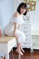 A woman sitting on top of a white dresser.