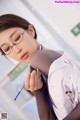 A woman in a white lab coat holding a syringe.