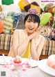 A woman sitting at a table with a birthday cake.