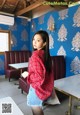 A woman standing in front of a blue wall in a restaurant.