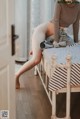 A woman sitting on top of a bed next to a door.